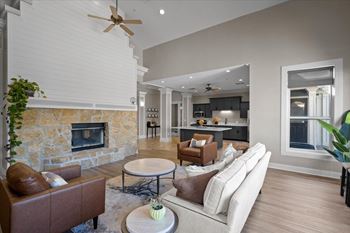 A living room with a stone fireplace and a brown leather couch.